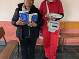 Laura and Jaqueline share gospel booklets with patients at Atahualpa school at Chaupiloma - June 3, 2023