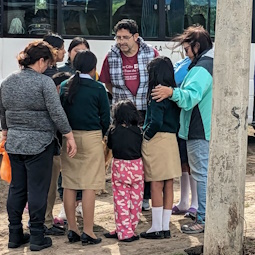 Dino praying with a family